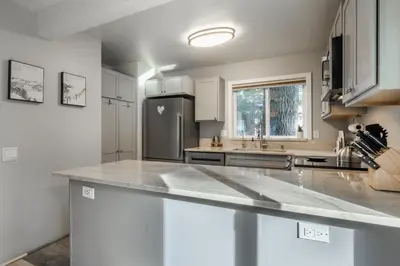 a kitchen with white cabinets and a stainless steel refrigerator at Wildflower 65 in Mammoth Lakes