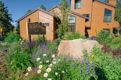 a sign in a garden in front of a building at Wildflower 65 in Mammoth Lakes