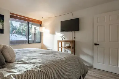 a bedroom with a bed and a television on the wall at San Sierra 19 in Mammoth Lakes