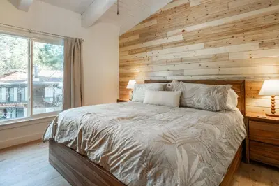 a bedroom with a wooden accent wall and a bed at Chateau De Montagne 4 in Mammoth Lakes
