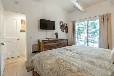 a bedroom with a bed and a flat screen tv at Chateau De Montagne 4 in Mammoth Lakes