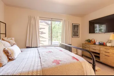 a bedroom with a bed with a dresser and a window at Seasons Four 165 in Mammoth Lakes