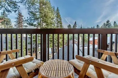 a balcony with two wooden chairs and a table at Bigwood 5 in Mammoth Lakes