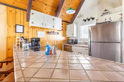 a large kitchen with wooden cabinets and a stainless steel refrigerator at Mammoth View Villas 20 in Mammoth Lakes