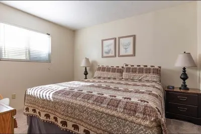 a bedroom with a bed and two lamps and a window at Mammoth View Villas 20 in Mammoth Lakes
