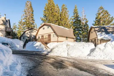 a house covered in snow next to a road at Mammoth View Villas 20 in Mammoth Lakes