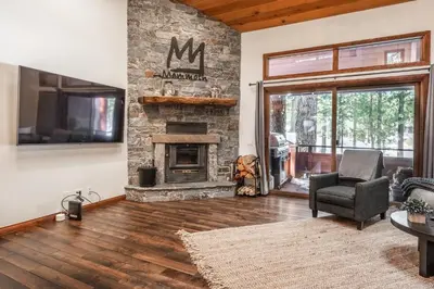 a living room with a stone fireplace and a tv at Winterset 20 in Mammoth Lakes