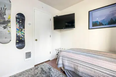 a bedroom with a snowboard hanging on the wall at Seasons Four 193 in Mammoth Lakes