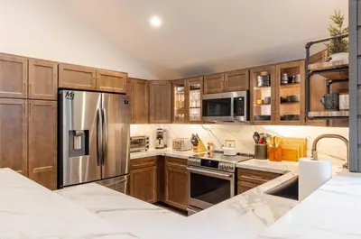 a kitchen with wooden cabinets and a stainless steel refrigerator at Snowcreek 25 in Mammoth Lakes