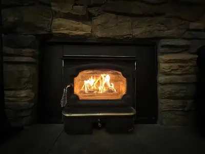 a stone fireplace with a fire in it at Aspen Creek 219 in Mammoth Lakes