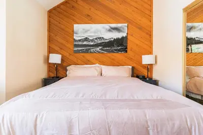 a bedroom with a large white bed with two lamps at Aspen Creek 219 in Mammoth Lakes