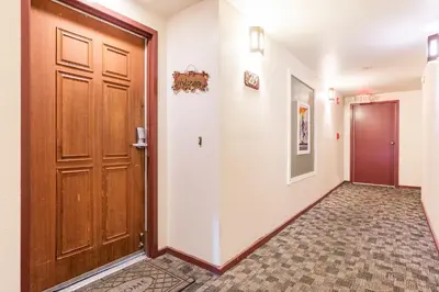a hallway with a wooden door and a tile floor at Aspen Creek 219 in Mammoth Lakes