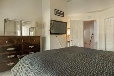a bedroom with a bed and a dresser and a flat screen tv at Sierra Park Villas 17 in Mammoth Lakes