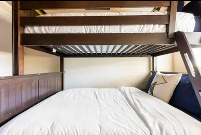 a bedroom with a bunk bed with white sheets at Mammoth View Villas 32 in Mammoth Lakes
