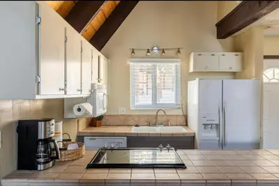 a kitchen with white cabinets and a white refrigerator at Mammoth View Villas 32 in Mammoth Lakes