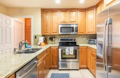 a kitchen with wooden cabinets and stainless steel appliances at Summit 43 in Mammoth Lakes