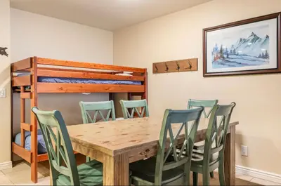 a dining room with a table and chairs and a bunk bed at Summit 43 in Mammoth Lakes