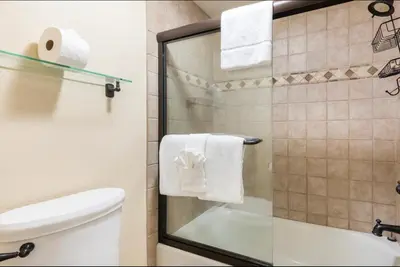 a bathroom with a toilet and a shower with towels at Summit 43 in Mammoth Lakes