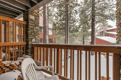 a porch with a bench on a deck with snow at Summit 43 in Mammoth Lakes