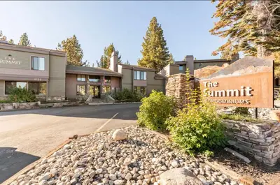 a sign for the summit apartments with a building at Summit 43 in Mammoth Lakes