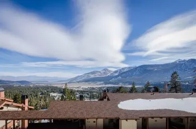 a person sitting on the roof of a house with mountains at 88 Bridges Lane in Mammoth Lakes