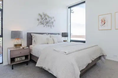 a white bedroom with a large bed and a table at 88 Bridges Lane in Mammoth Lakes
