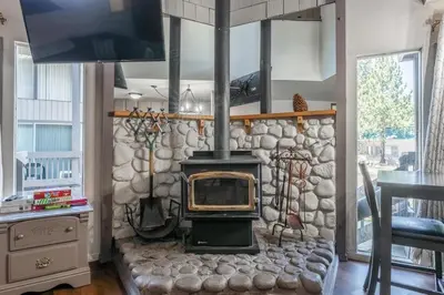a stone wall with a stove in a living room at Sierra Park Villas 45 in Mammoth Lakes
