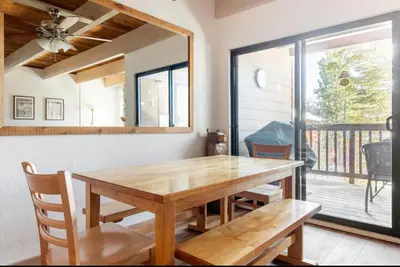 a dining room with a wooden table and a window at Val DIsere 14 in Mammoth Lakes