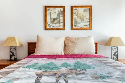 a bed with two lamps and two pictures on the wall at Val DIsere 14 in Mammoth Lakes