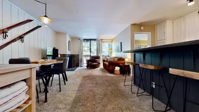 a kitchen with a table and chairs and a living room at Crestview 45 in Mammoth Lakes