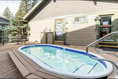 a hot tub on a deck next to a house at Crestview 45 in Mammoth Lakes