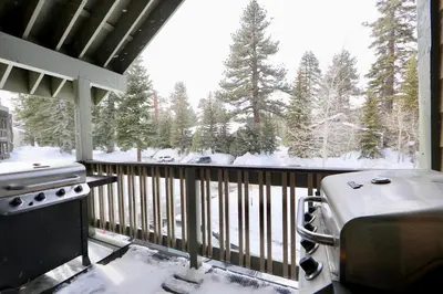 a balcony with a stove and snow covered trees at Crestview 45 in Mammoth Lakes