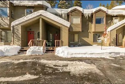 a house with a red door in the snow at Forest Creek 21 in Mammoth Lakes