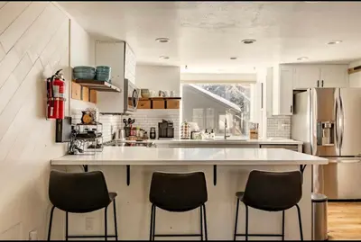 a kitchen with a large white counter and four chairs at Forest Creek 21 in Mammoth Lakes