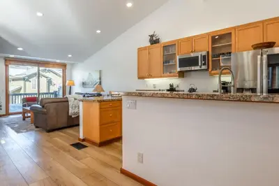 a kitchen with wooden cabinets and a living room at Snowcreek 778 in Mammoth Lakes