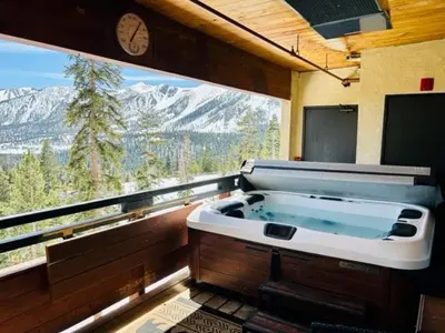 a large bath tub in a room with a large window at Bridges 210 in Mammoth Lakes