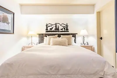 a white bedroom with a large white bed at Bridges 210 in Mammoth Lakes