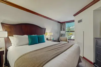a bedroom with a large bed with blue pillows at Everline Resort & Spa 534 in Olympic Valley