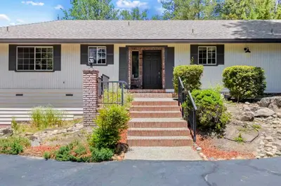 a house with a staircase leading to the front door at Whispering Pines in Oakhurst
