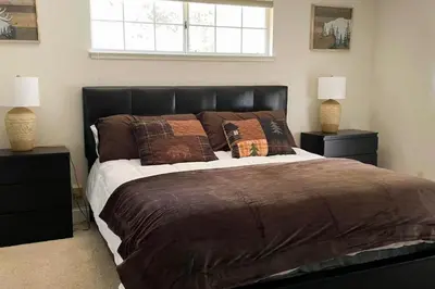a bedroom with a large bed with two lamps at Whispering Pines in Oakhurst
