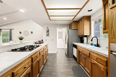a kitchen with wooden cabinets and a stove top oven at Whispering Pines in Oakhurst
