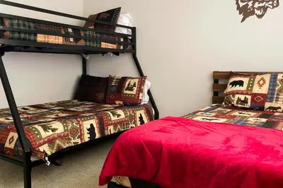 a bedroom with two beds and a bunk bed at Whispering Pines in Oakhurst
