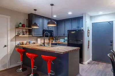 a kitchen with blue cabinets and red bar stools at Ski In Canyon Lodge Modern 1 bdrm Pacman and Garage in Mammoth Lakes