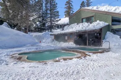 a pool of water in a yard covered in snow at Ski In Canyon Lodge Modern 1 bdrm Pacman and Garage in Mammoth Lakes