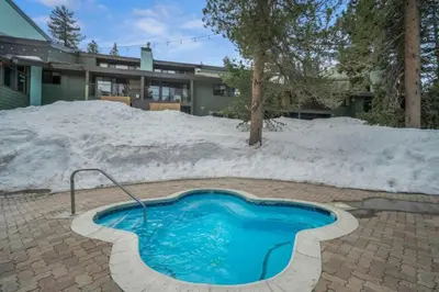 a swimming pool in the snow in front of a house at Ski In Canyon Lodge Modern 1 bdrm Pacman and Garage in Mammoth Lakes