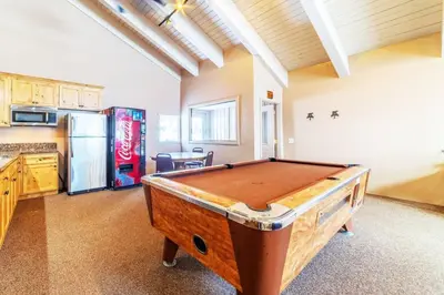 a kitchen with a pool table in a room at Ski In Canyon Lodge Modern 1 bdrm Pacman and Garage in Mammoth Lakes