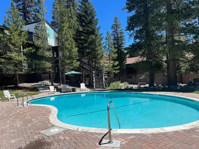 a large swimming pool in a yard with trees at Ski In Canyon Lodge Modern 1 bdrm Pacman and Garage in Mammoth Lakes