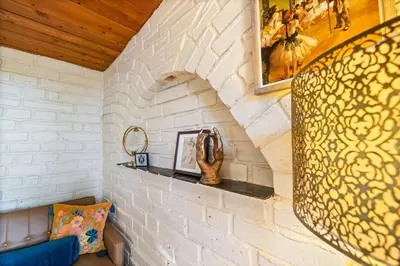 a living room with a white brick wall at 16 mi to Yosemite-1 mi to Oakhurst-Anthro Decor in Oakhurst