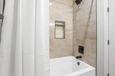 a bathroom with a tub and a white shower curtain at Tahoe Toasty - 3 Bedroom Home Near Sledding Hill in South Lake Tahoe