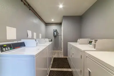 a laundry room with a row of white machines at Adventure by Day Cozy Nights Family Alpine Condo in Mammoth Lakes